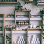 Creative interior design of small shop with wooden shelves full of assorted colorful bottles and green plants