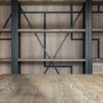 Empty wooden shelves near wall with decorative elements and table in modern spacious loft styled conference hall