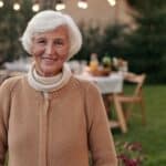 Happy elderly woman with gray hair laughing and looking at camera in terrace