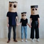 A Family Wearing Diy Cardboard Box Mask While Holding Each Other's Hands