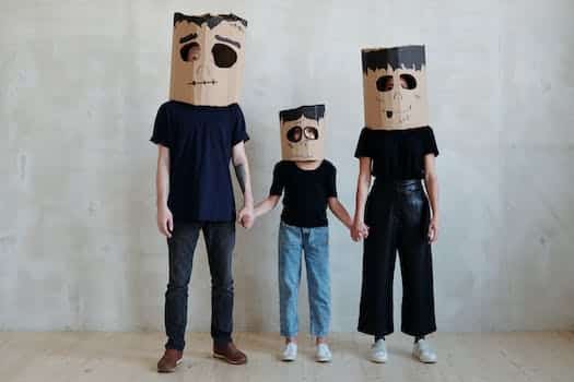 A Family Wearing Diy Cardboard Box Mask While Holding Each Other's Hands