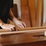 Experienced artisan doing woodwork on table in workshop