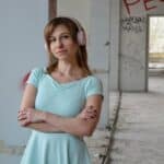 Serene woman listening to song in headset in old building