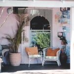 Sunny porch with comfy chairs and potted plants