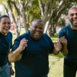 Three People In Blue Crew Neck Shirts With Happy Faces