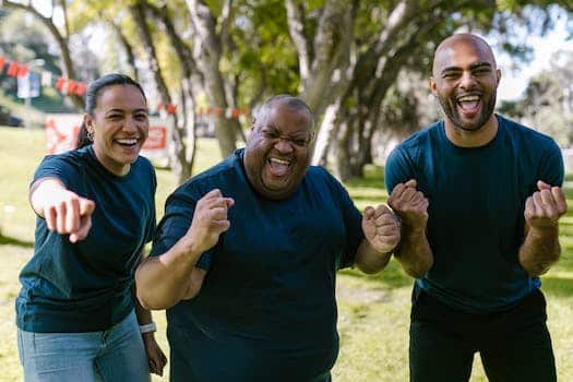 Three People In Blue Crew Neck Shirts With Happy Faces