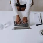 Woman in White Long Sleeve Shirt Using Macbook Pro