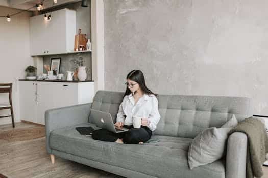 Woman Sitting On Sofa While Working At Home