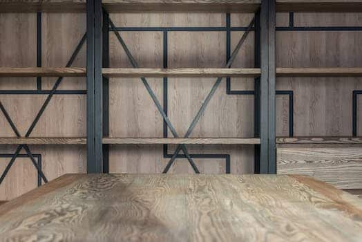 Empty wooden shelves near wall with decorative elements and table in modern spacious loft styled conference hall