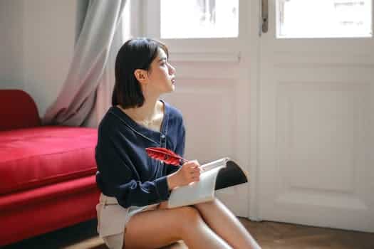 Thoughtful woman writing in notebook at home