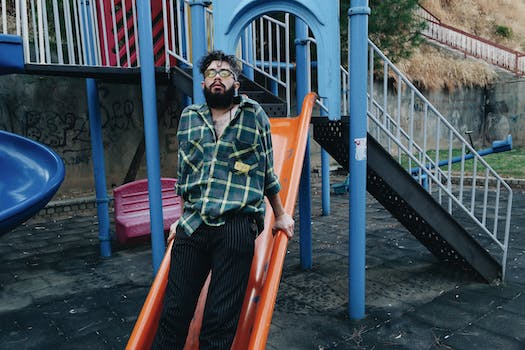 A Man Leaning on the Playground Slide