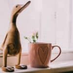 Brown Wooden Duck Figurine Near Brown Ceramic Mug