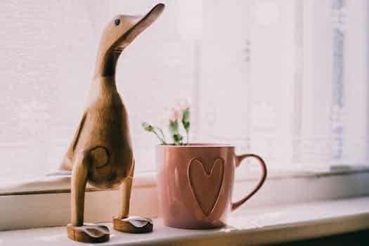 Brown Wooden Duck Figurine Near Brown Ceramic Mug