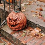 Carved pumpkin placed on stairs on Halloween