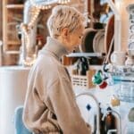 Woman against dishware on rack in kitchen