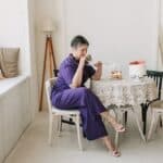 Woman in Purple Jumpsuit Holding Cup