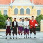 A group of people in traditional clothing standing in front of a building