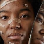 A Woman Protesting with Messages on Band Aids