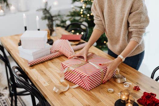 Woman Packing Christmas Presents on Table