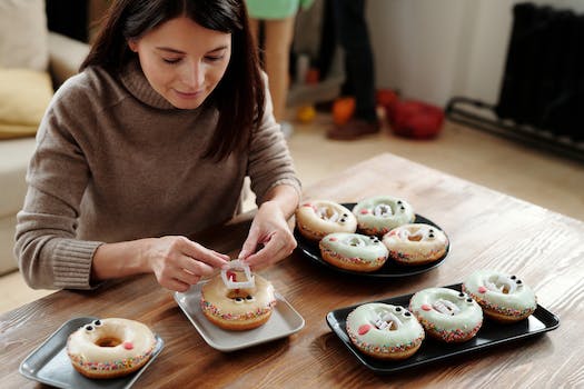 Woman Placing A Plastic Fang On A Donut